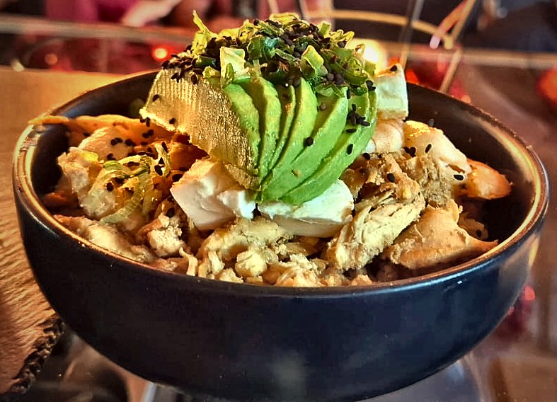 Yakimeshi en tazón negro con pollo, camarón, queso Philadelphia, aguacate, cebollín y ajonjolí