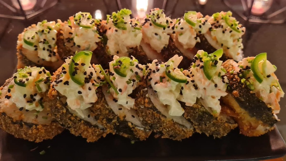 Califa: sushi empanizado cubierto con ensalada de surimi, jalapeño y ajonjolí negro